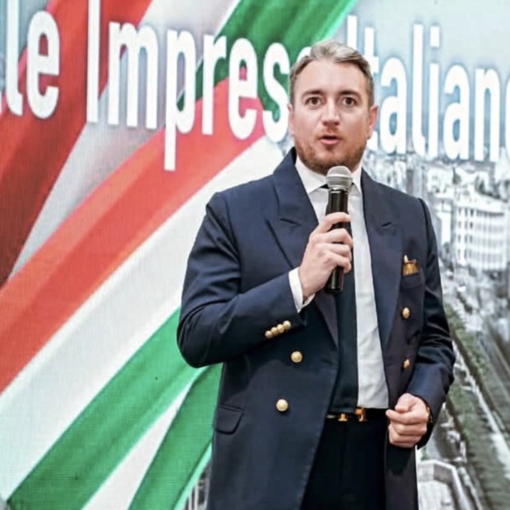 Enrico Celiberti parla al microfono davanti a un grande tricolore italiano